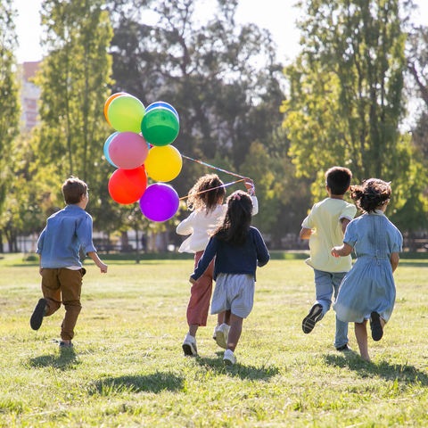 children running and playing with a balloon