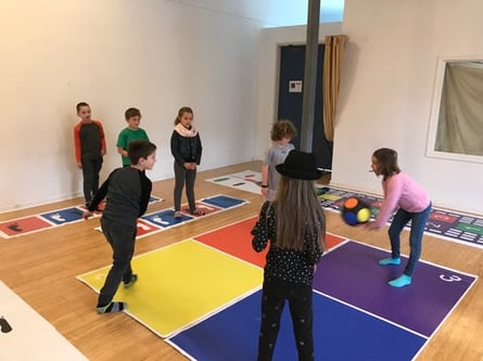 children playing four square during indoor recess