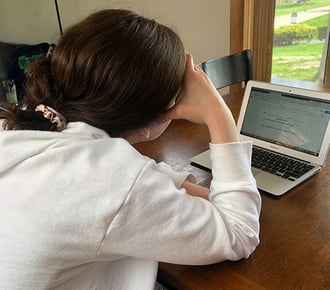 an anxious student stares at their computer screen