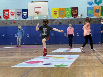 children using a roll-out activity in the gymnasium for physical education