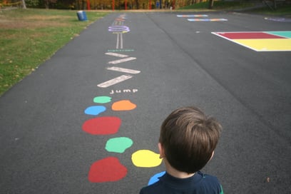 a child in front of an outdoor sensory pathway on the playground