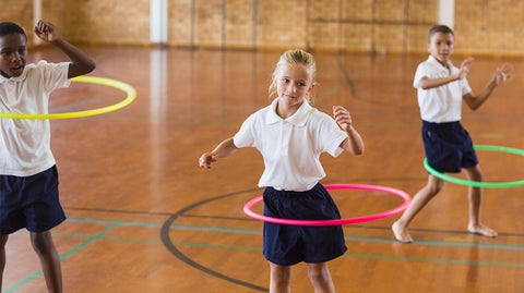 kids hula hooping in the gym