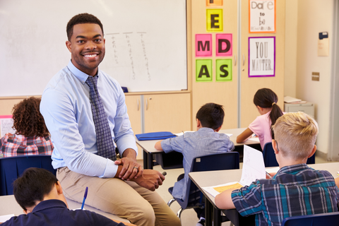 teacher in a classroom smiling